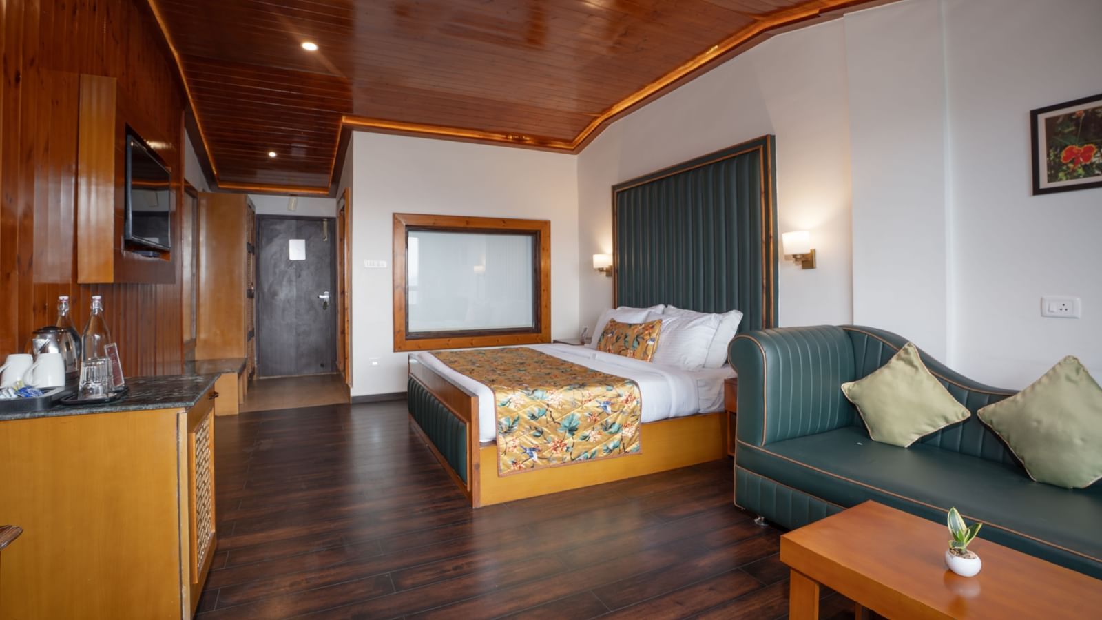 Premium Valley View Room at Summit North Star, Gangtok featuring a bed, a seating area with sofa and centre table, a cabinet table with tea and coffee maker, and a flat TV screen.