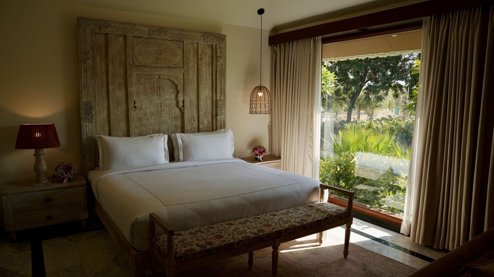 A room with a bed and a large window on the side at Surpura Bagh.