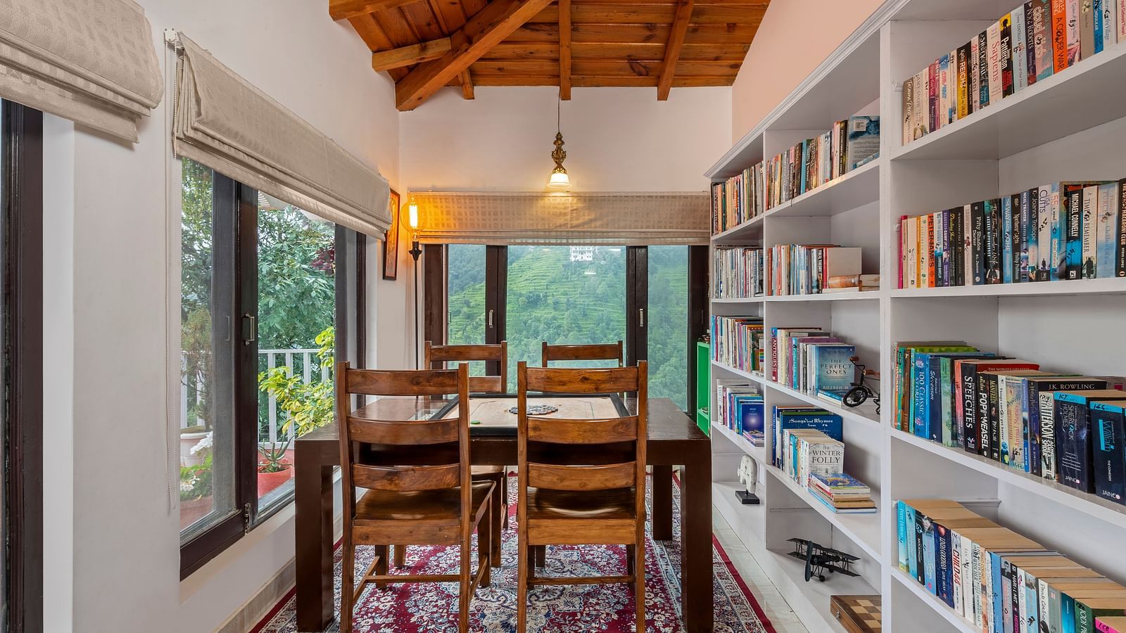 An image of a room filled with books in book shelves and at the centre there are chairs and centre table - Suvaasa, Ramgarh