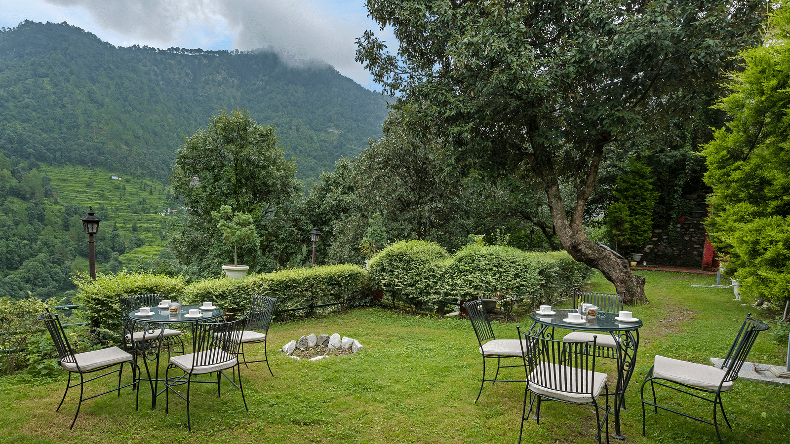 An image of a lawn with seating arrangements for groups with a backdrop of mountain view  - Suvaasa, Ramgarh 