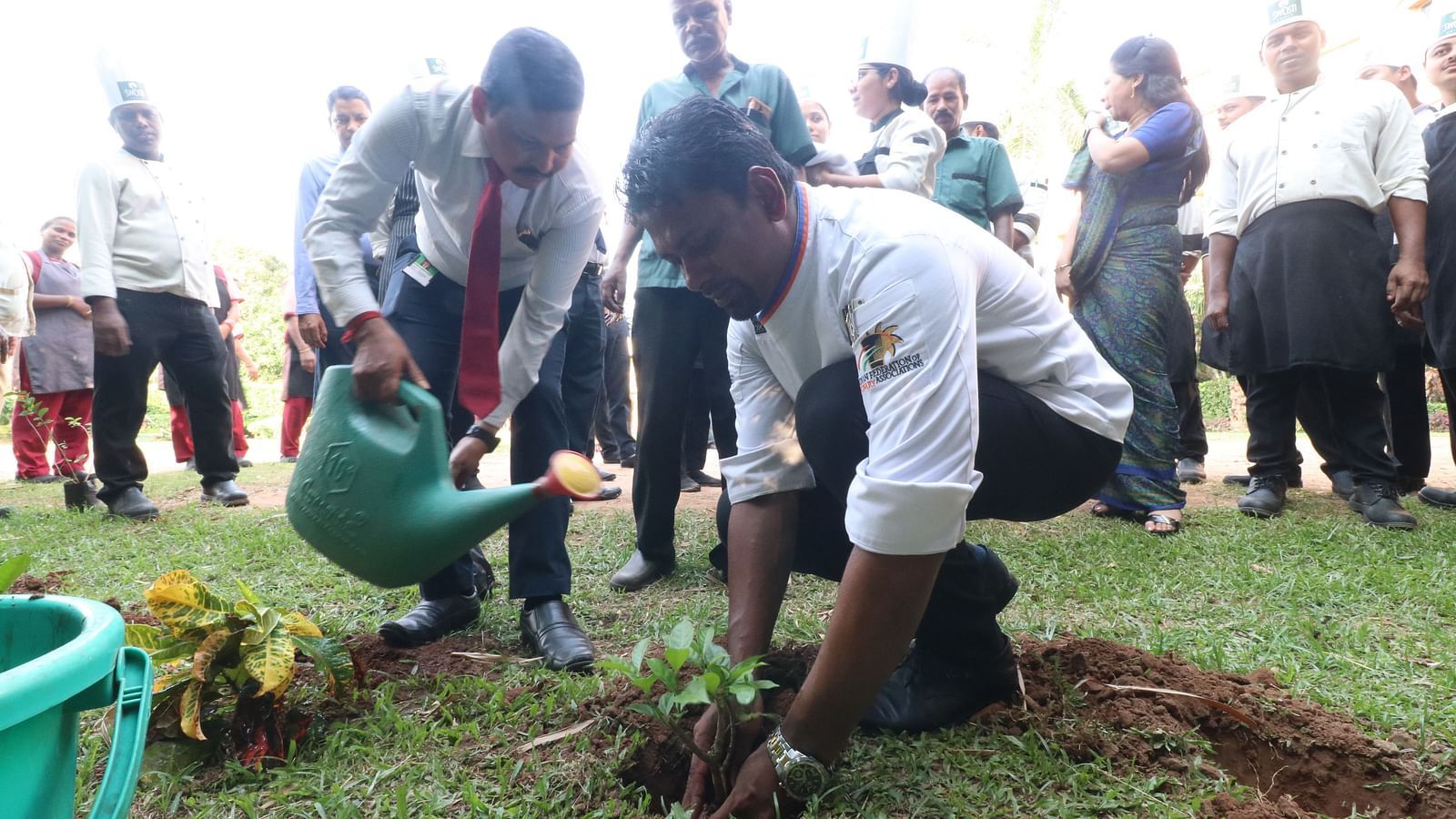 People planting and watering saplings at Swosti Resorts