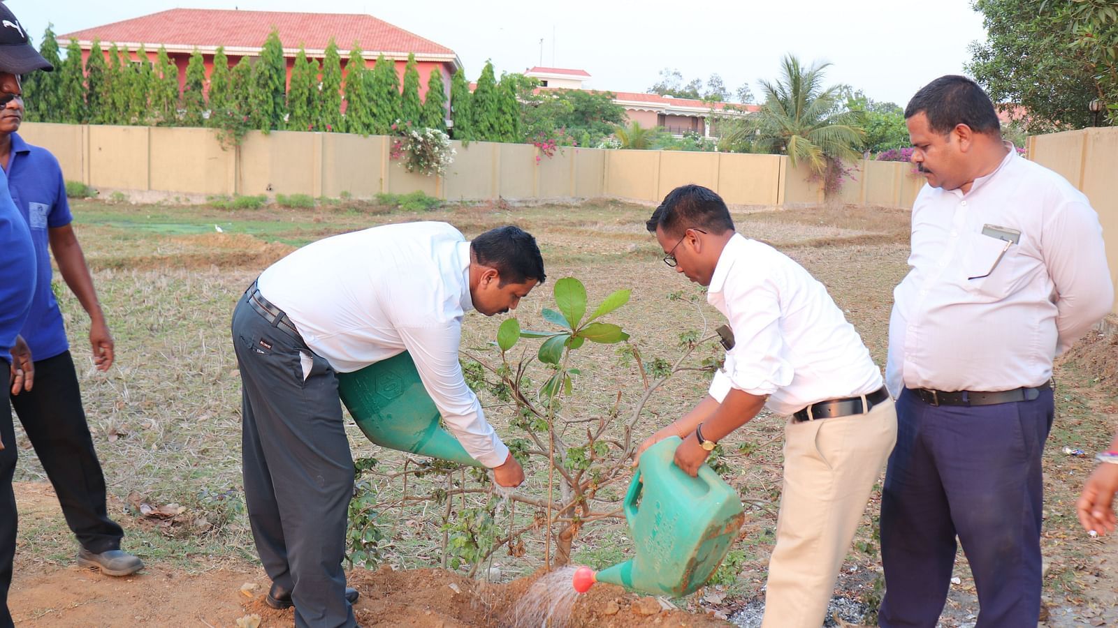 People planting a sapling at Swosti Resorts during the day