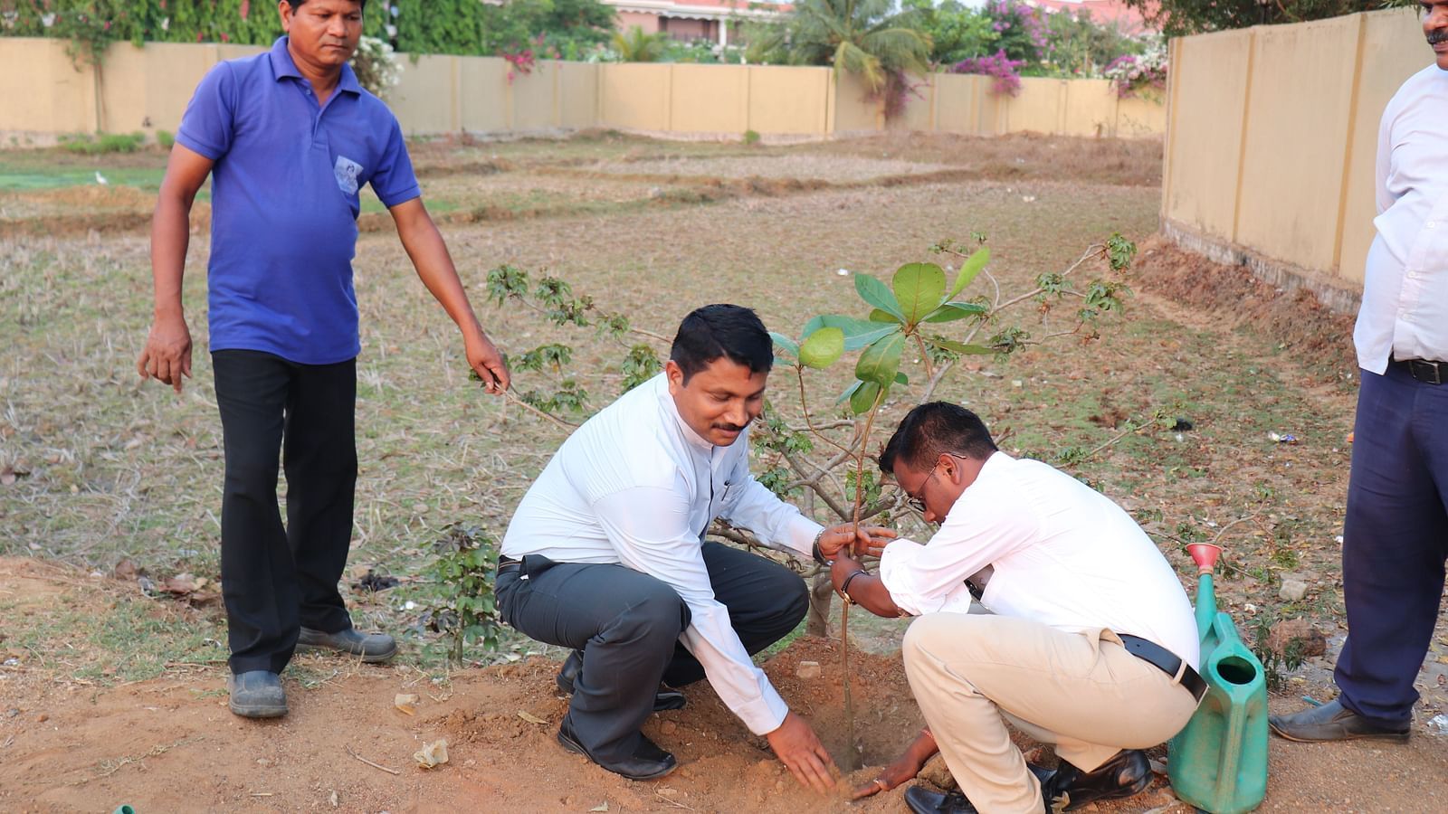 People planting a sapling at Swosti Resorts during the day