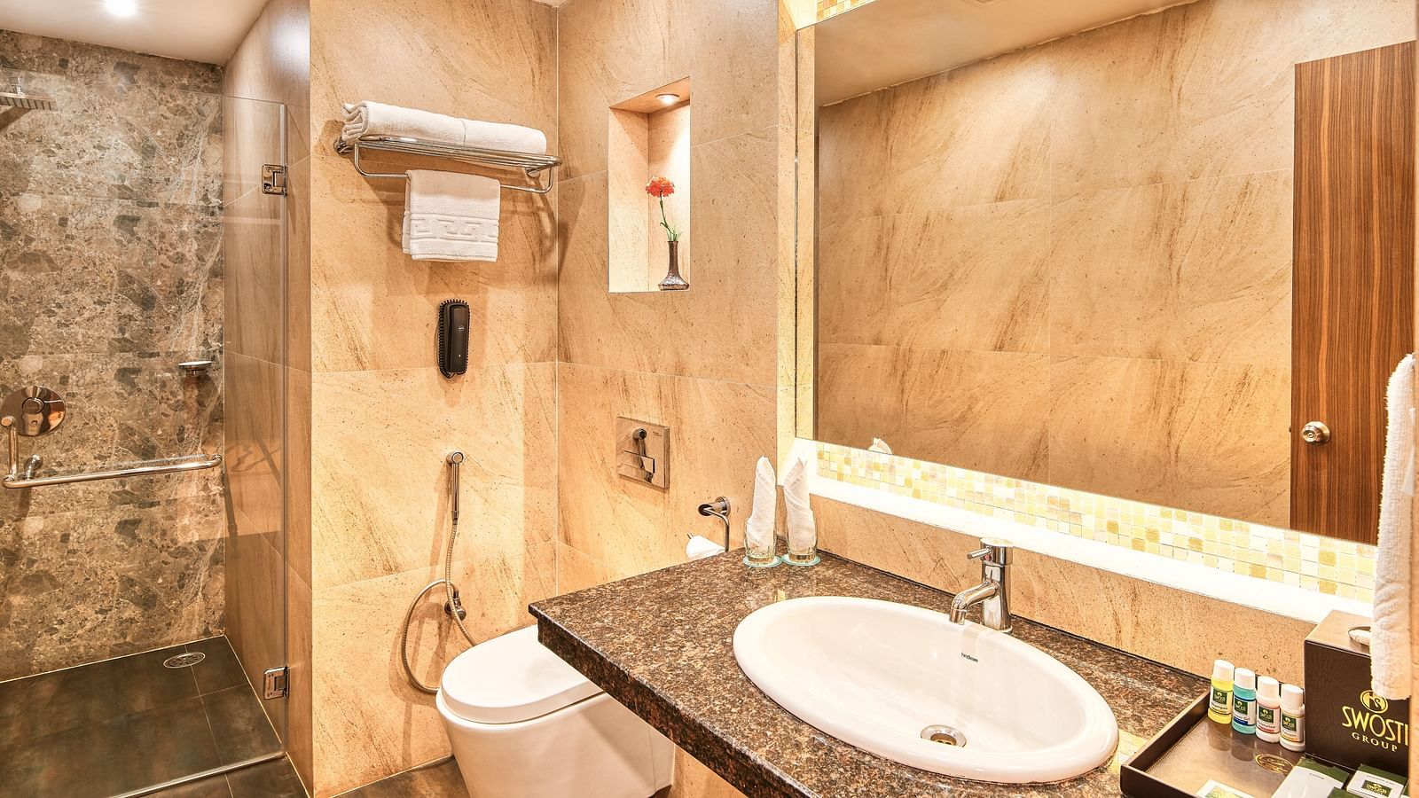 Image of deluxe room washroom with sink and and modern amenities at Swosti Grand, Bhubaneswar
