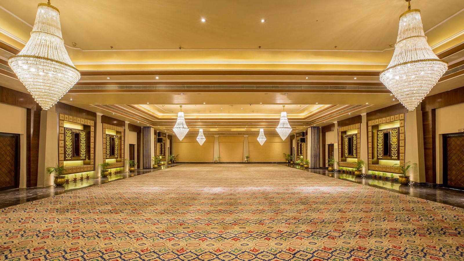 Banquet hall with various chandelier lighting creating a warm and welcoming ambiance.