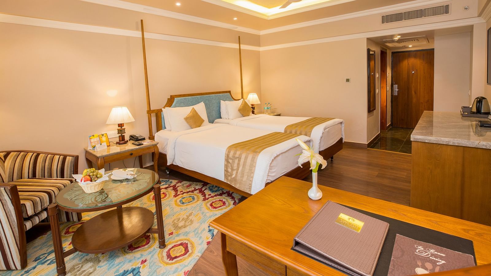 Spacious bed with wooden furniture surrounding the room for storage and relaxation.
