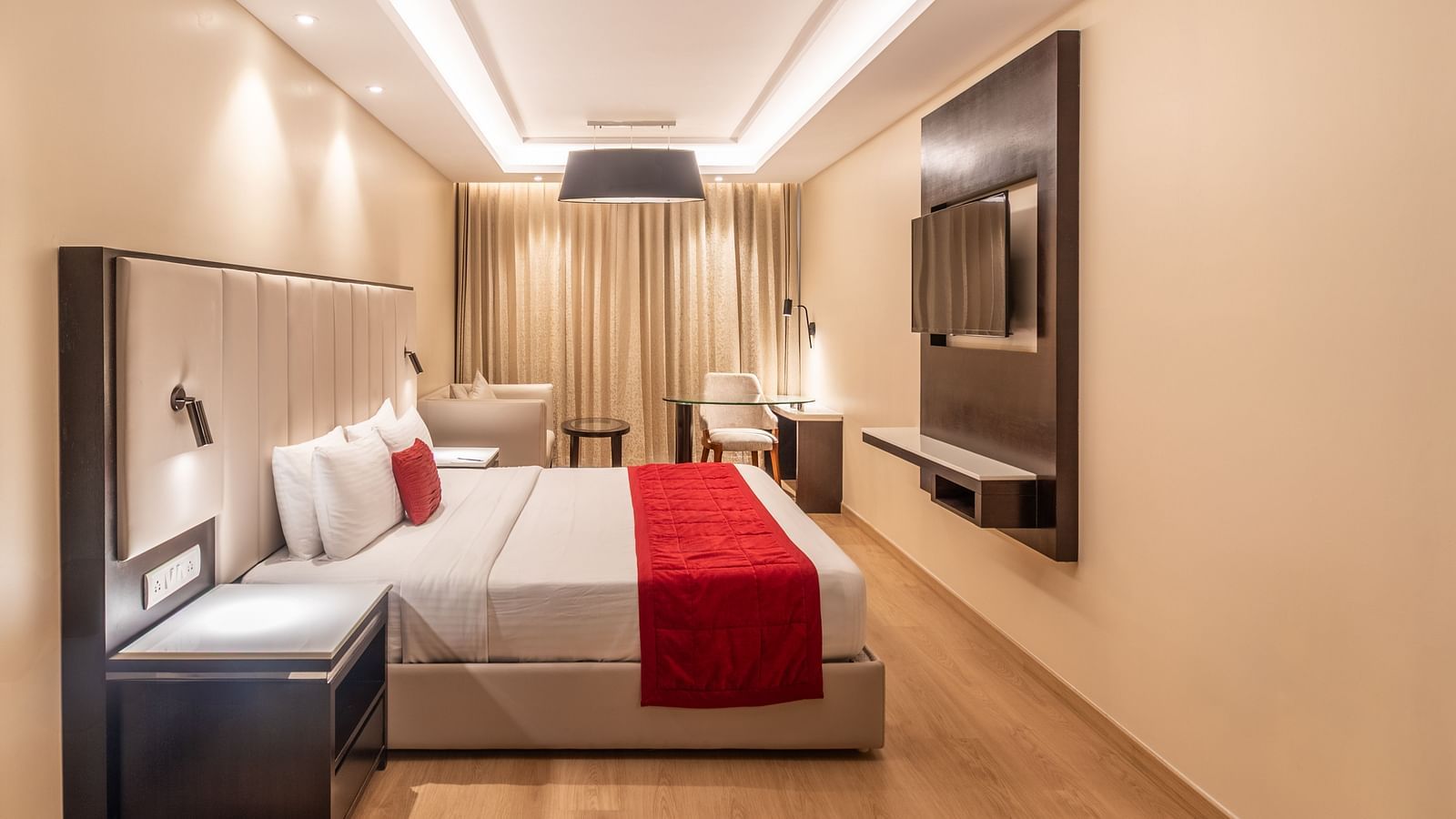 Cozy double room featuring a red runner and a flat-screen TV of Grand Suite- TGI Grand Fortuna, Krishnagiri Main Road, Hosur