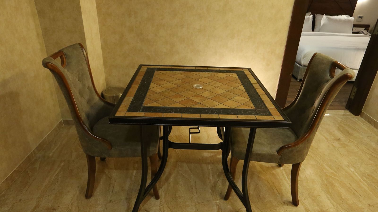 A small dining area or game area with a table and four chairs in Premium Suite - TGI SPS Grand, Coimbatore