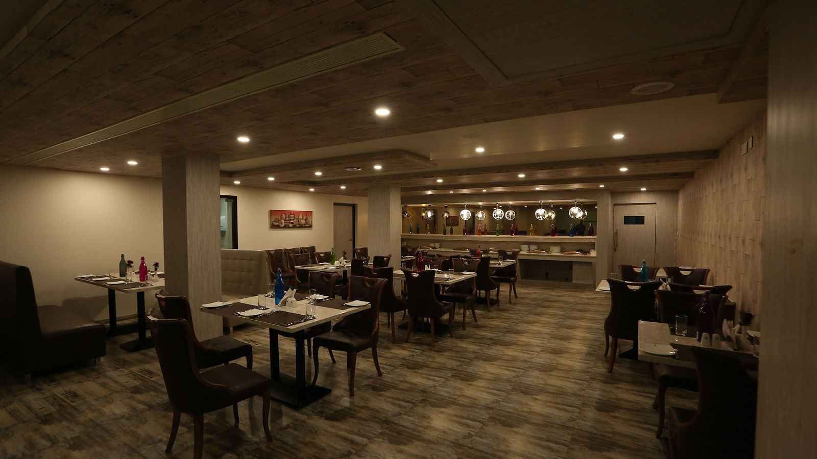 A restaurant with tables and chairs, designed with warm lighting and a cosy ambience - TGI SPS Grand, Coimbatore