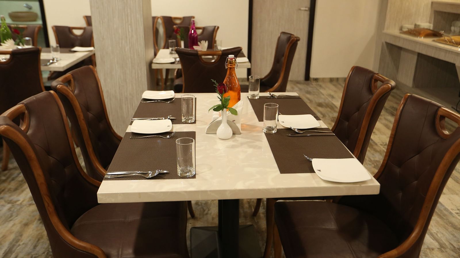 A dining area with set tables surrounded by chairs - TGI SPS Grand, Coimbatore