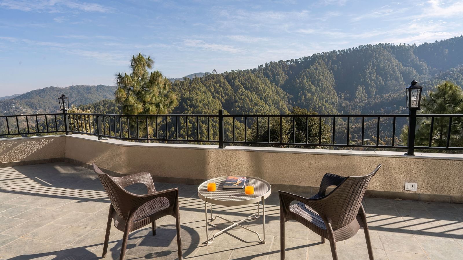 A spacious balcony at The Chamomile Estate, furnished with outdoor seating and offering serene mountain views.