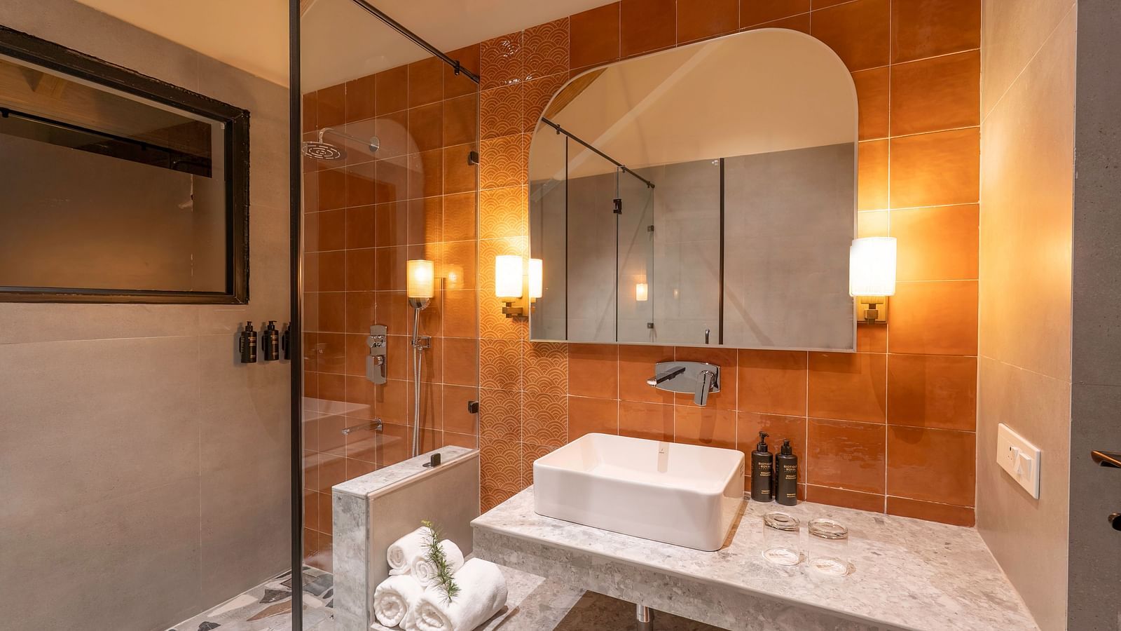 Stylish bathroom with a modern sink and a walk-in shower with a glass door separating them at The Chamomile Estate.