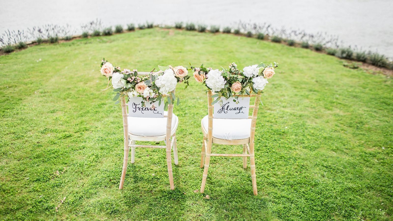 two chairs with a bouquet of flowers kept above it in a lawn area