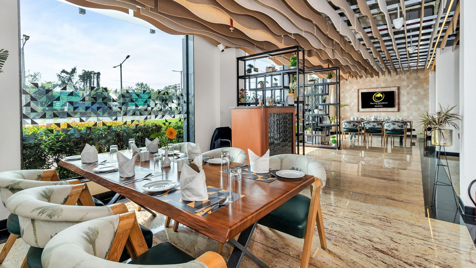 A stylish restaurant with set tables near a large window offering an outdoor view | The Citi Residenci Hotel Banskopa