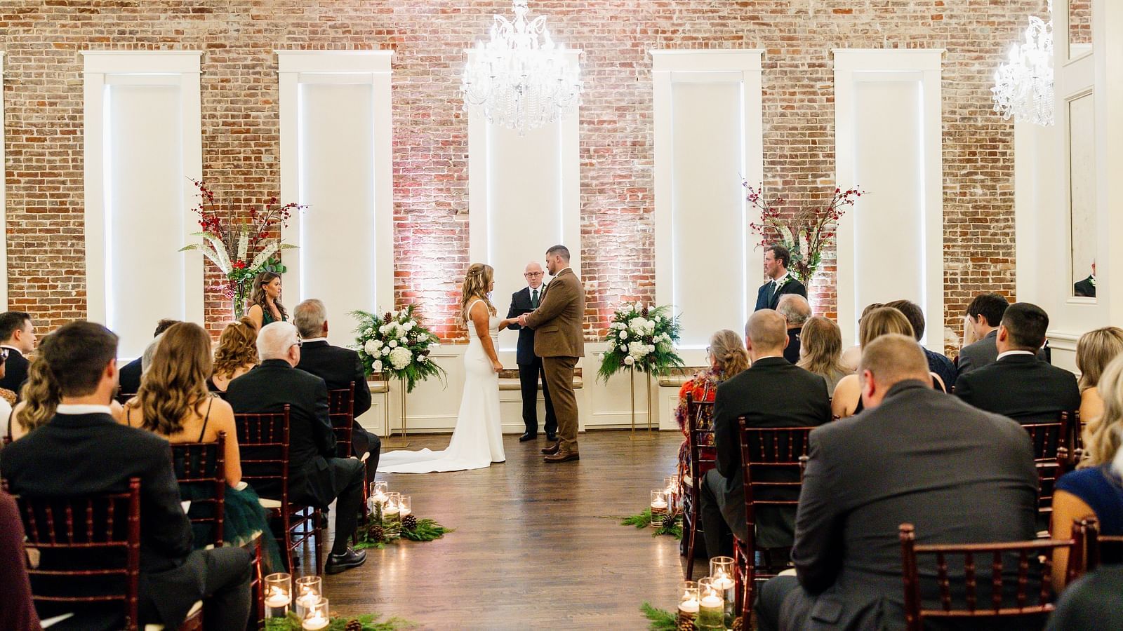 A couple standing, facing each other, in a hall full of people sitting in theater style seating arrangement - The Grand Hotel & Ballroom, McKinney