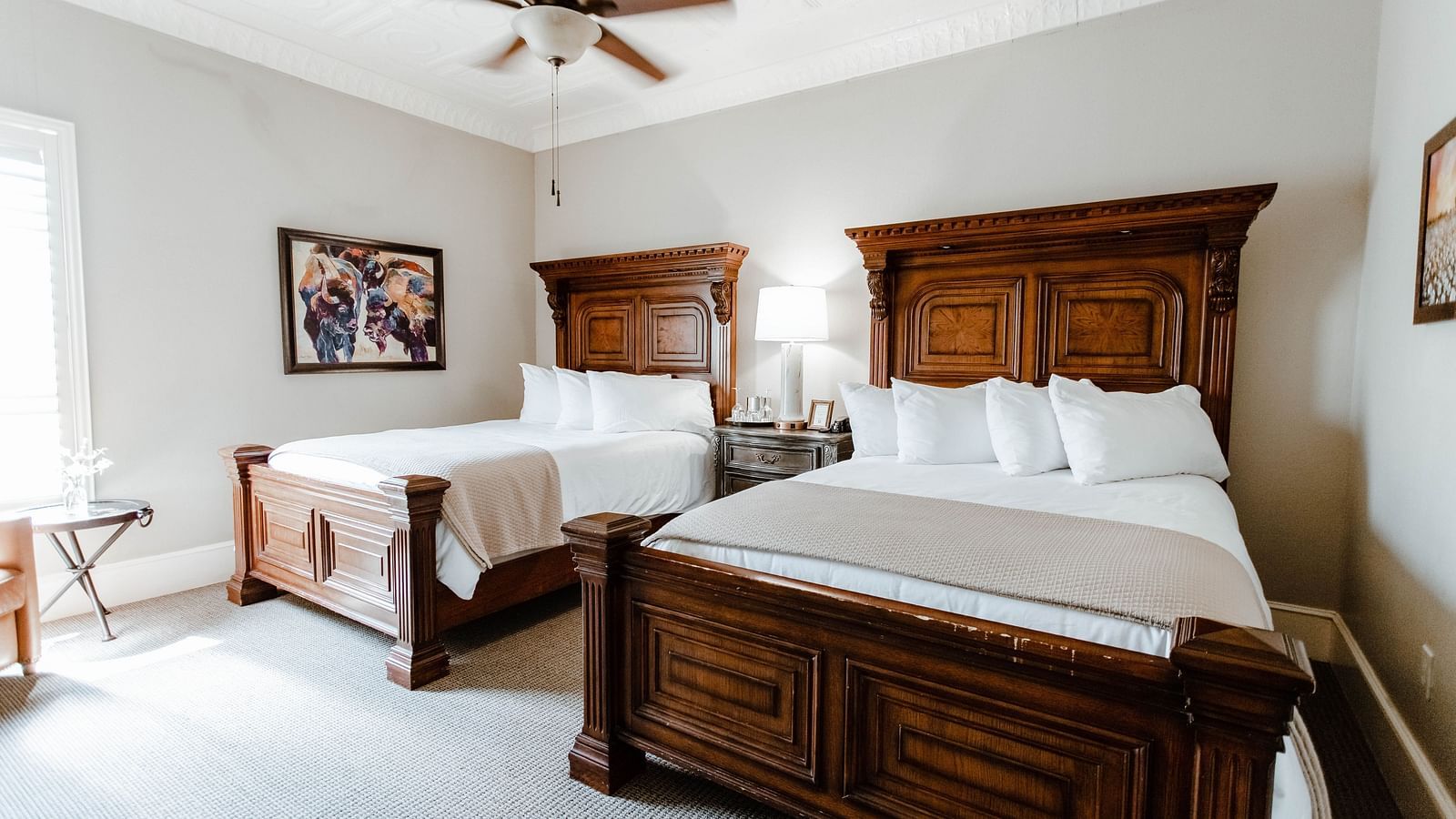 A charming bedroom with wooden furniture, elegant decor, and a ceiling fan, offering a serene and classic atmosphere - The Grand Hotel & Ballroom, McKinney
