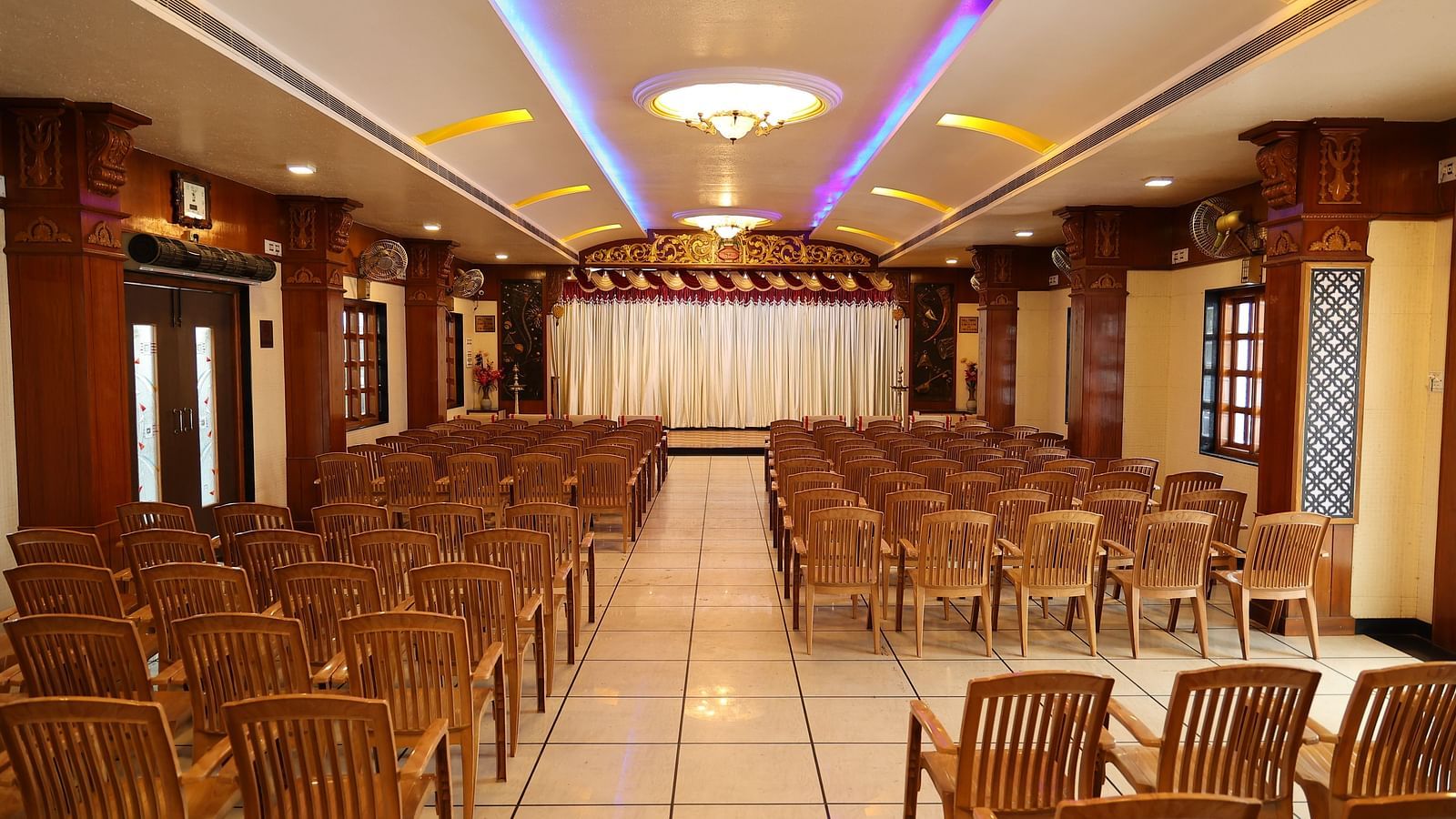 image of the banquet hall at the grand krishna room with a lot of chairs arranged in the hall 