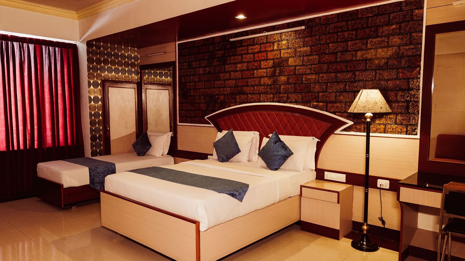 image of the Deluxe Room featuring a double be with modern interiors and warm lighting in the room at The Grand Krishna Rooms in Bengaluru