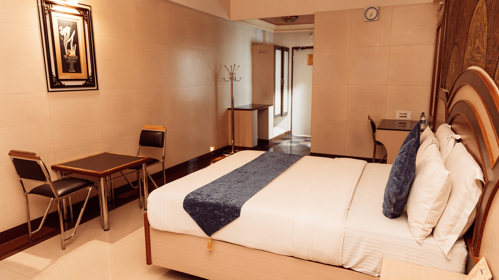 full view image of the executive room at The Grand Krishna Rooms in Bengaluru featuring a double bed along with a two seater dining area