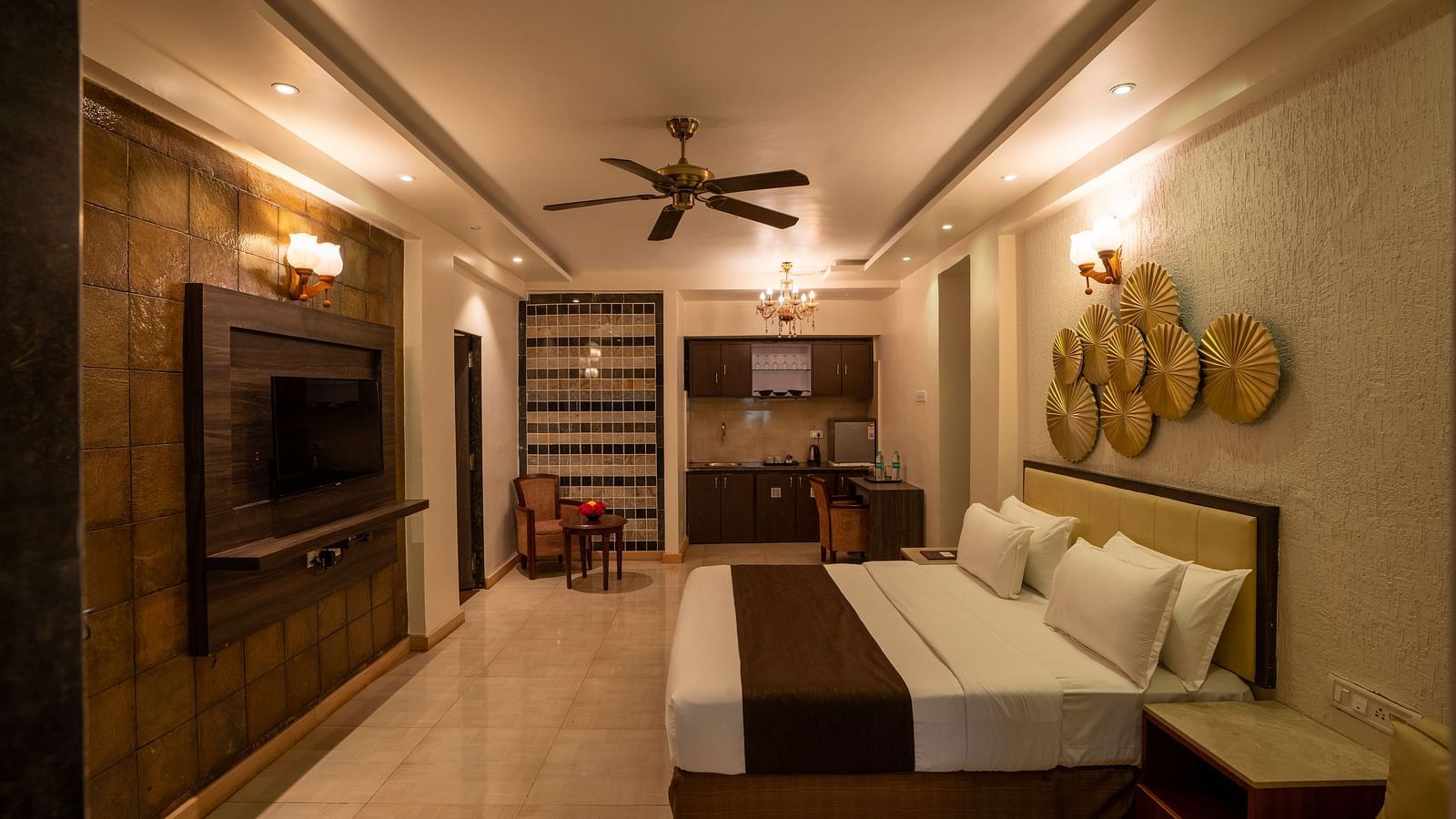 Interior view of a guest room with a seating area, ceiling fan, and wall décor - The Grand Legacy Resort & Spa