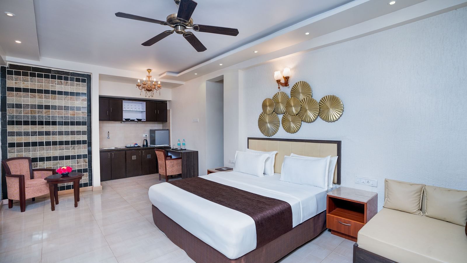 A image of a spacious room with a king size bed and a couch along with several  wall decors | The Grand Legacy Resort and Spa
