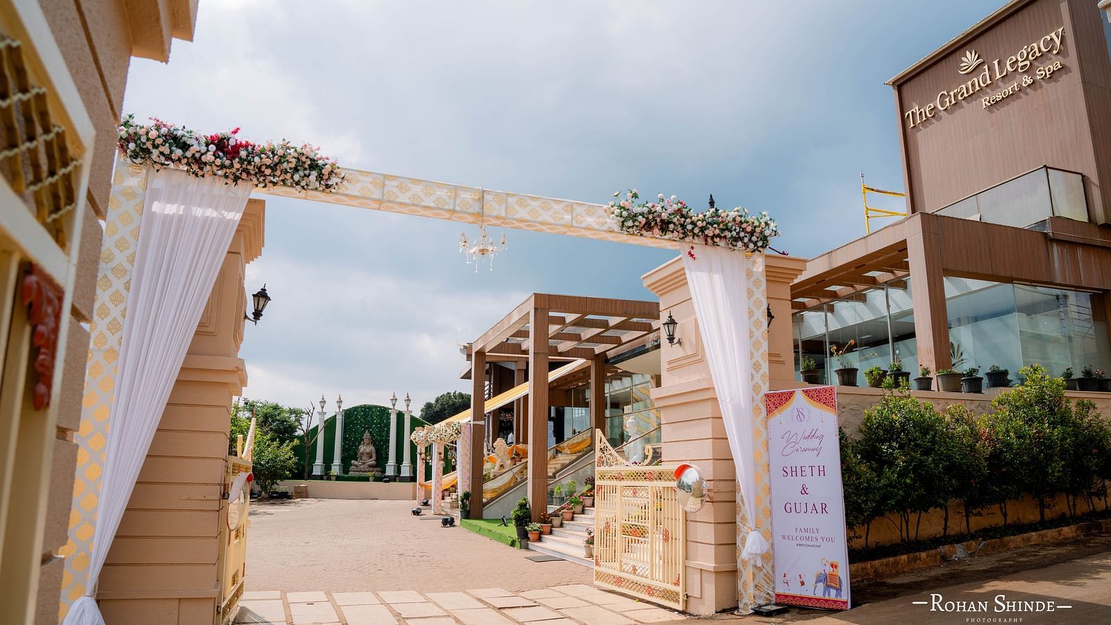 An ornate wedding entrance decorated with fabric and floral arrangements, leading into a venue under a cloudy sky - The Grand Legacy Resort and Spa