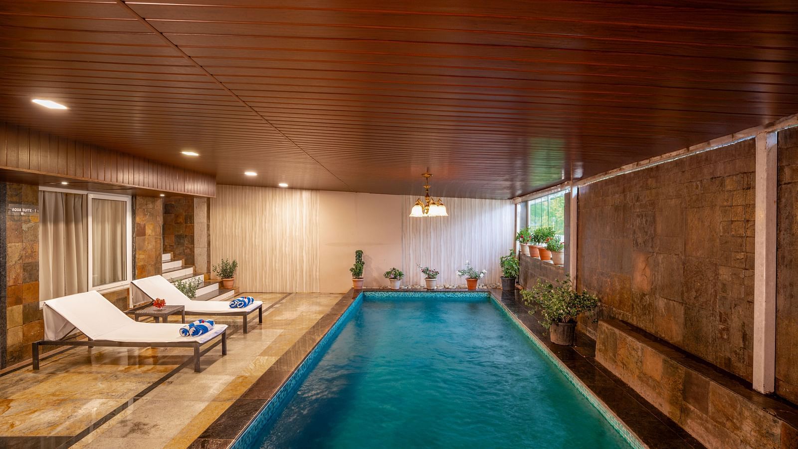 Indoor pool area with lounge chairs and ambient lighting - The Grand Legacy Resort & Spa