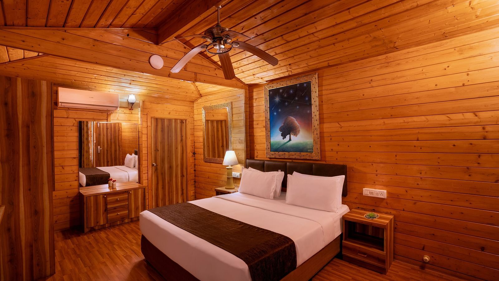 A cosy wooden cabin-style room with warm lighting and rustic decor, featuring a large bed and wooden walls.