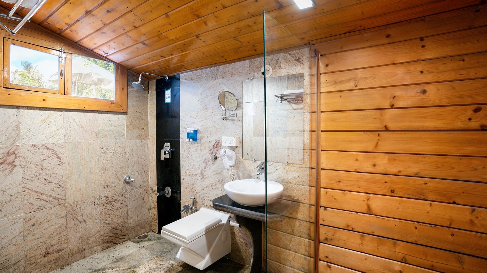 Bathroom with wooden walls, glass shower enclosure, and modern fixtures - The Grand Legacy Resort & Spa