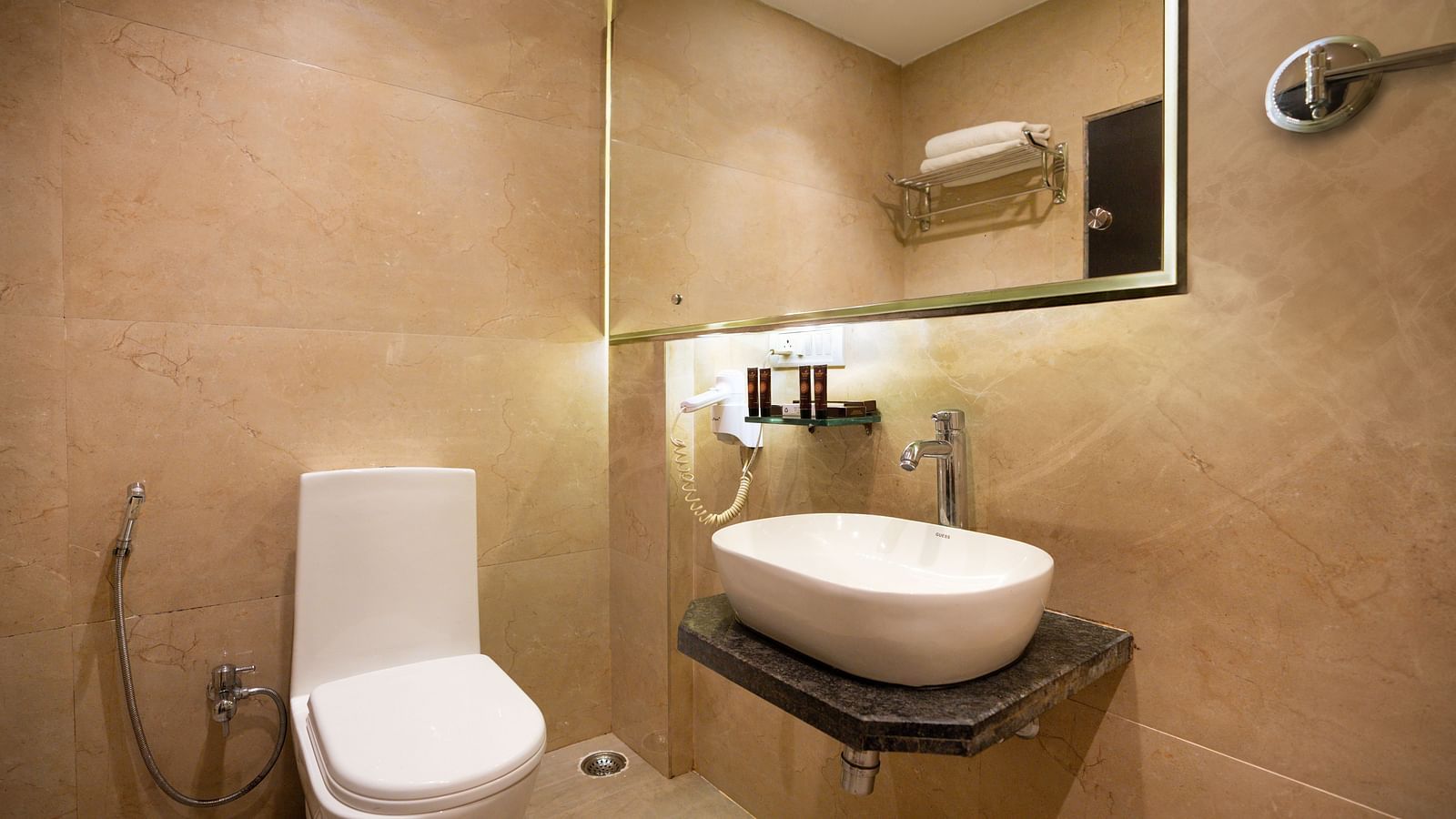 Modern bathroom with toilet, sink, and wall-mounted mirror - The Grand Legacy Resort & Spa