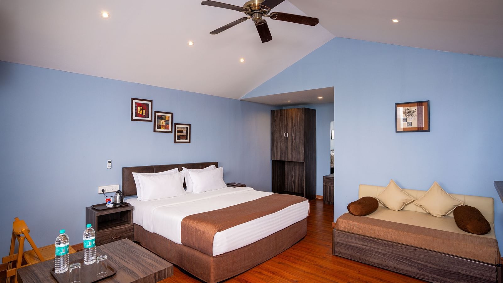 A image of a spacious room with a king size bed and a couch along with several  wall decors | The Grand Legacy Resort and Spa