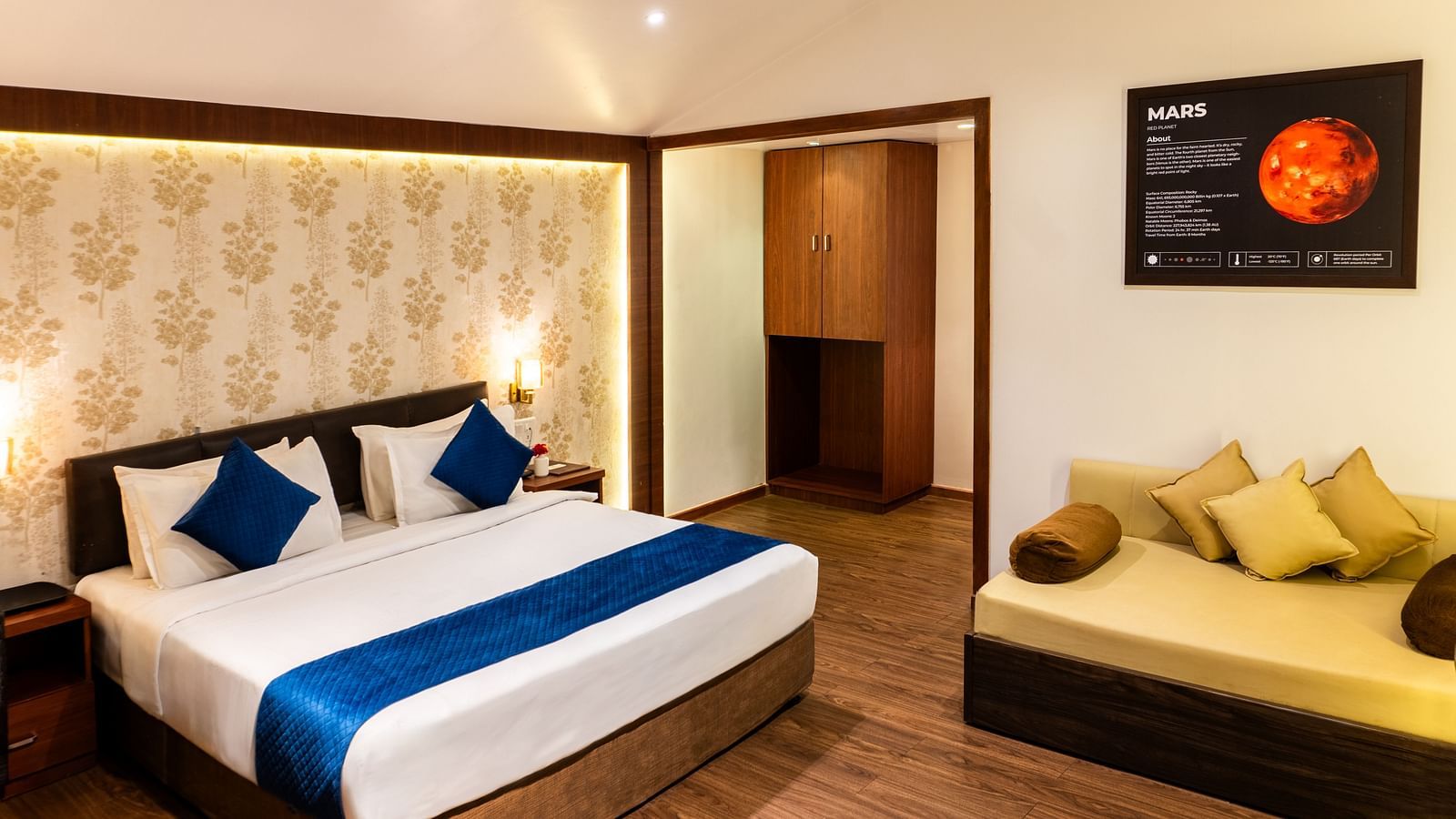 Lawn View Tent Room at The Grand Legacy Resort and Spa featuring room with double bed, blue accents, warm lighting, wood flooring, a lounge area, and Mars-themed wall art.