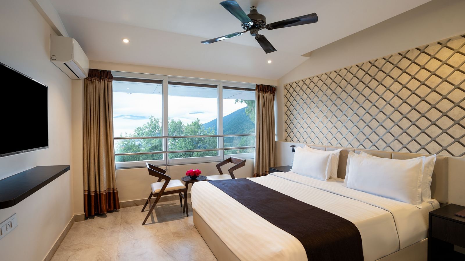  A bright, airy room with a contemporary design, featuring a large bed, modern furnishings, and a ceiling fan.