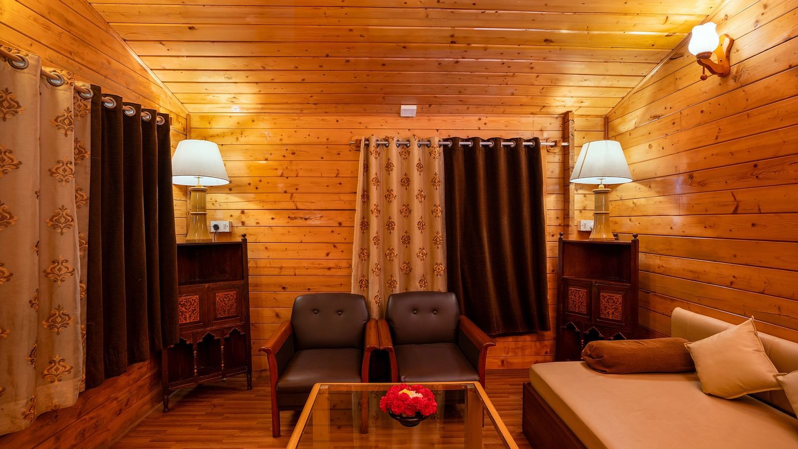 A shot of the living room at the resort featuring a couch and two sofas with a small centre table  and wooden furnishing | The Grand Legacy Resort and Spa