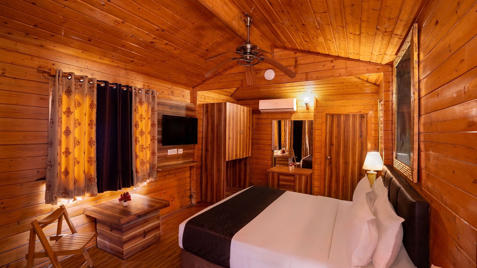 A modern, stylish room with a wooden ceiling, featuring a large bed and elegant lighting for a warm ambience.