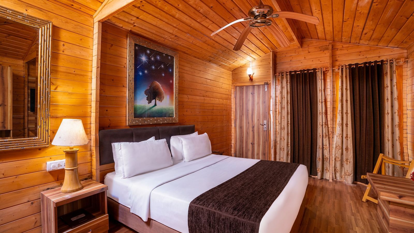 A image of a spacious room with a king size bed and a couch along with several  wall decors | The Grand Legacy Resort and Spa
