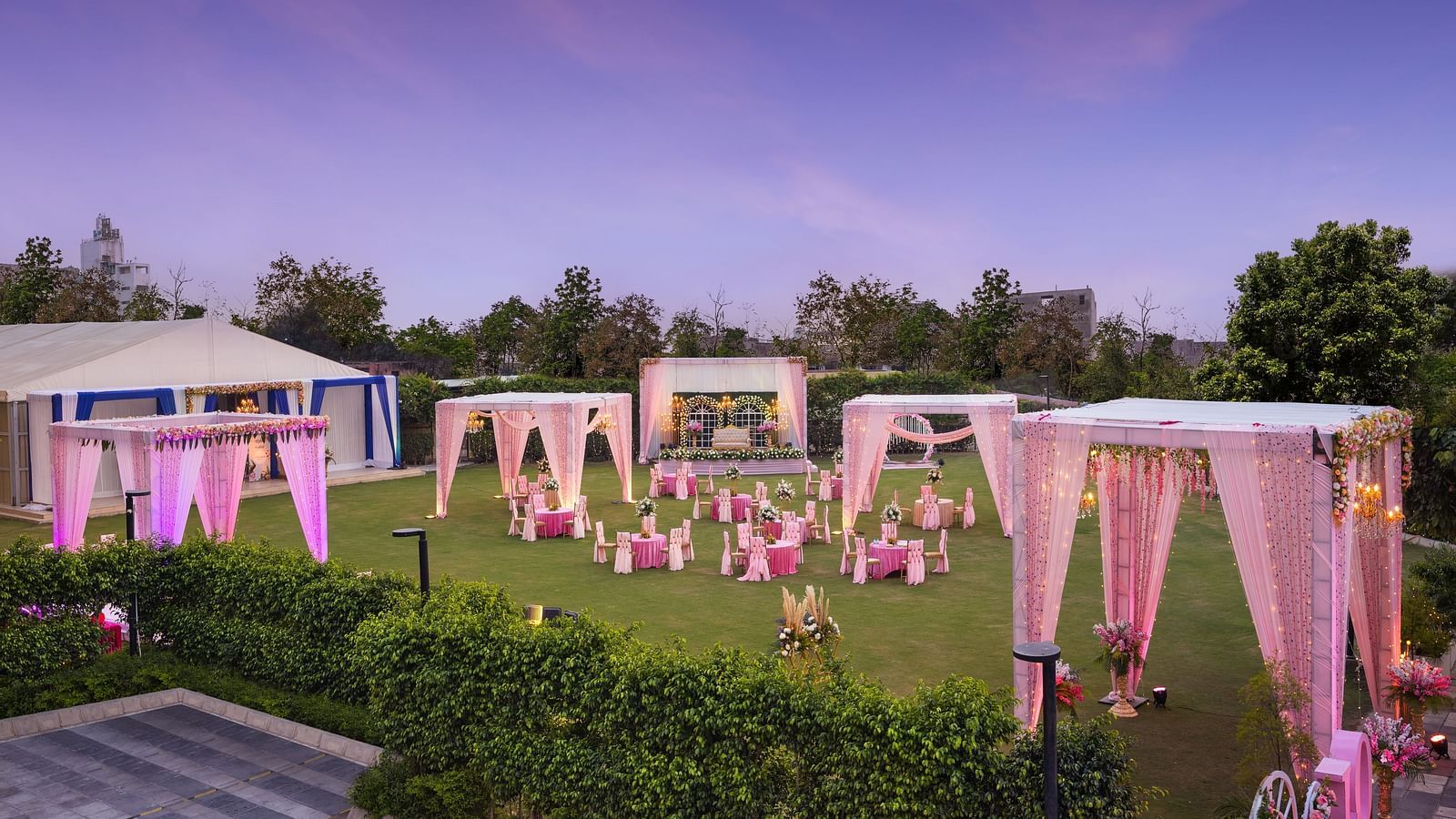 a view of a group of canopies in an open space with clusters of tables and chairs scattered across the space - The Hideaway Banquets & Lawns, Greater Noida