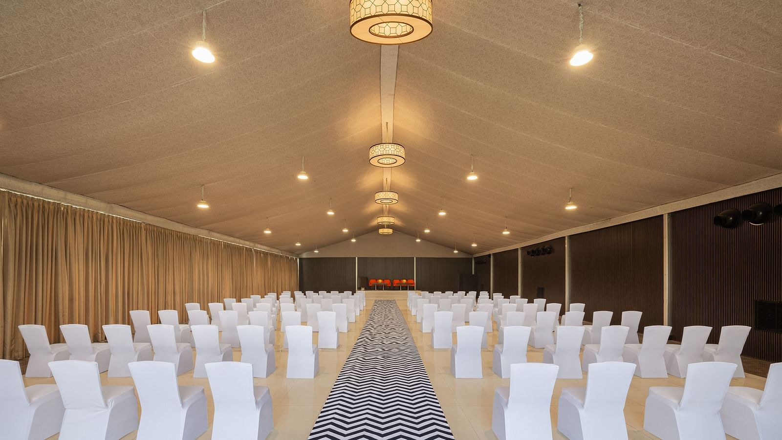a classroom type setting with chairs placed facing the other end of the hall on each side of a pathway - The Hideaway Banquets & Lawns, Greater Noida