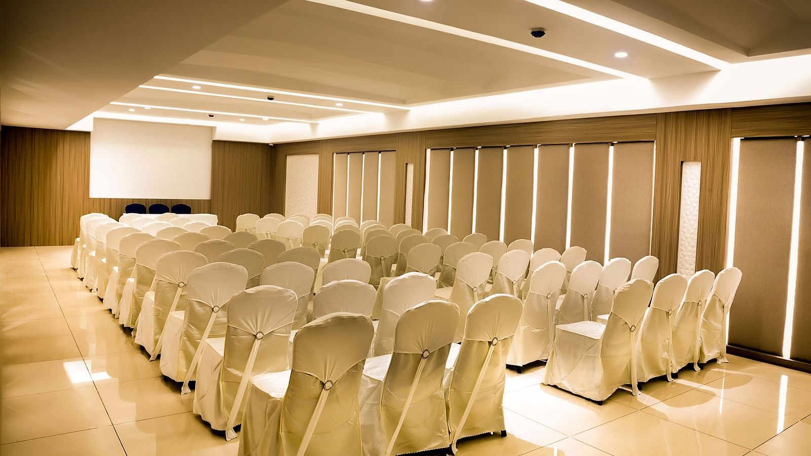 view of event hall with white chairs and warm lights of The Mayberry, Tiruppur