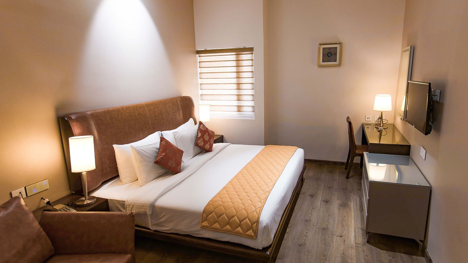image of a king size bed and a TV of a Premium Room of The Mayberry, Tiruppur