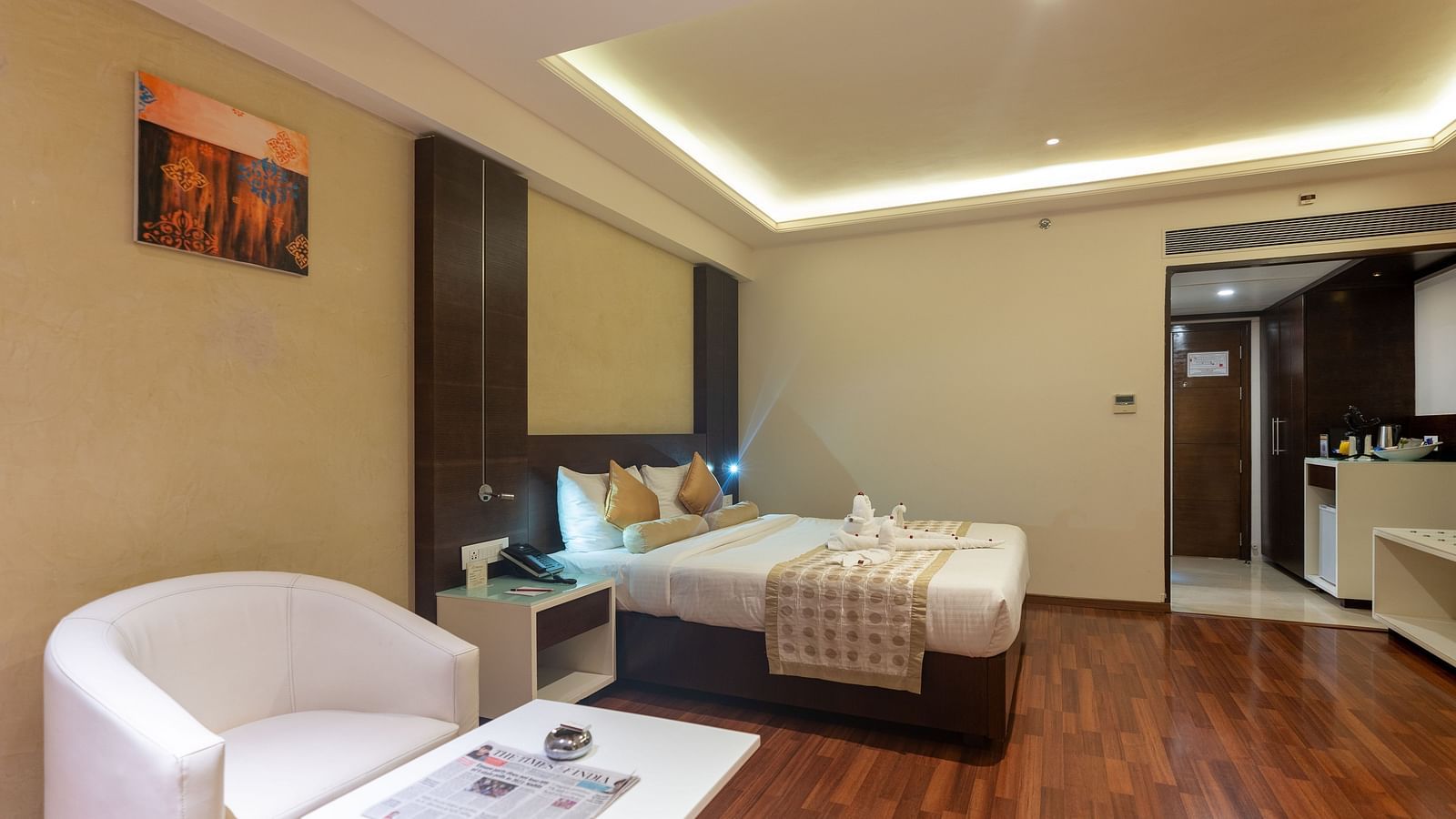 Luxury Room with king size bed, side table, sofa set and table at The President Hotel, Hubli