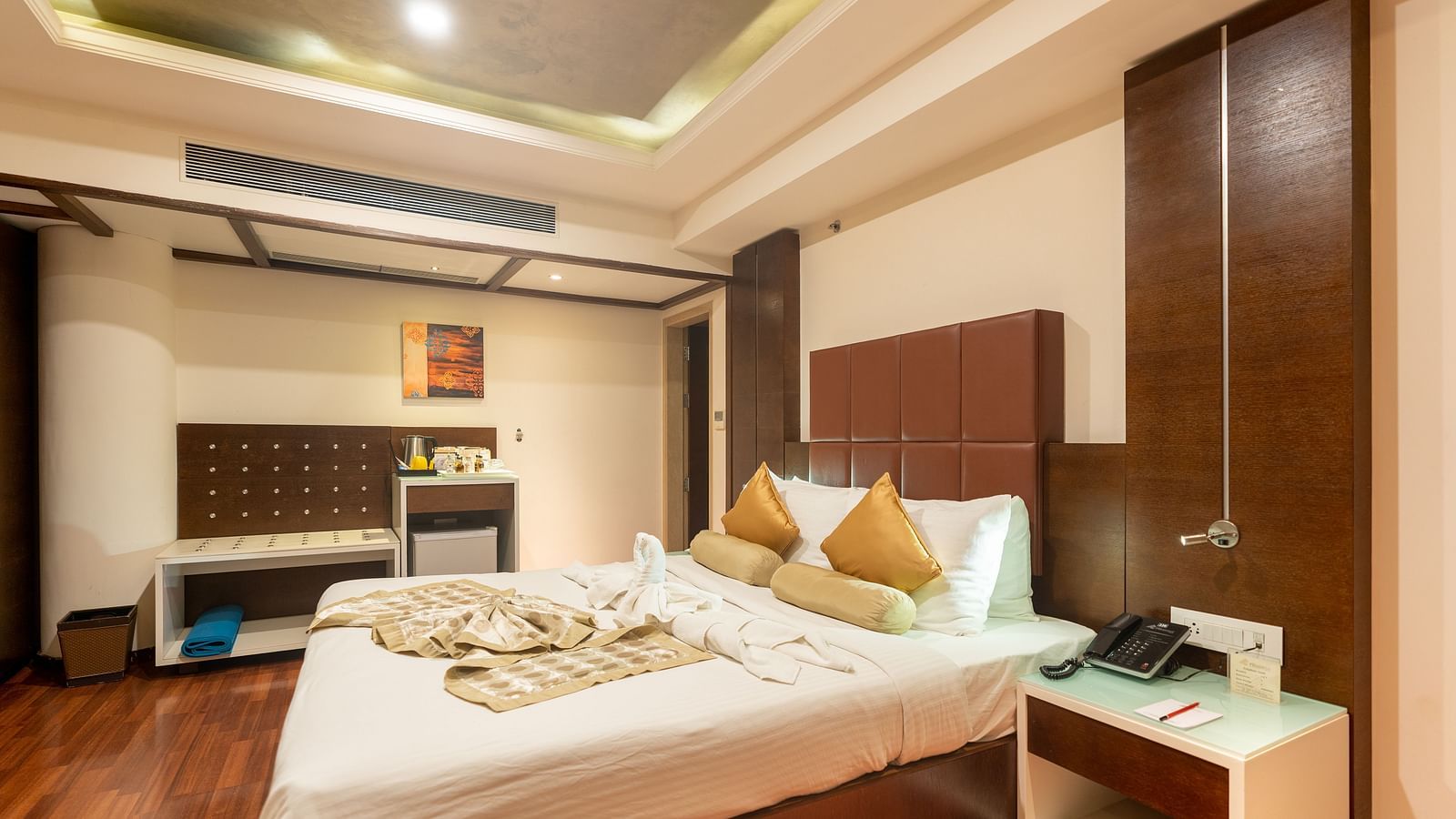 Club Suite with king size bed and a side table at The President Hotel, Hubli