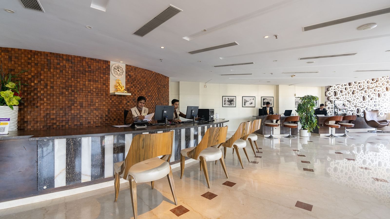 An image showcasing the hotel reception area of The President Hotel, Hubli with people working