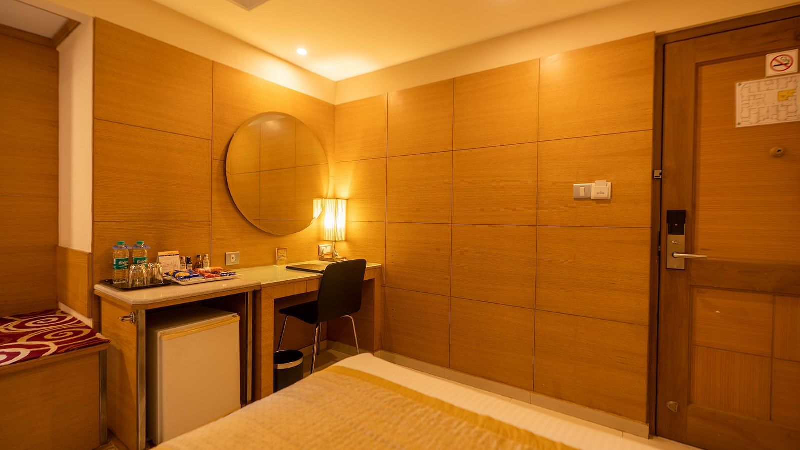 Modern and cosy hotel room with a spacious bed, seating area, sleek furnishings, and soothing lighting for a relaxing stay -The President Hotel Jayanagar, Bangalore