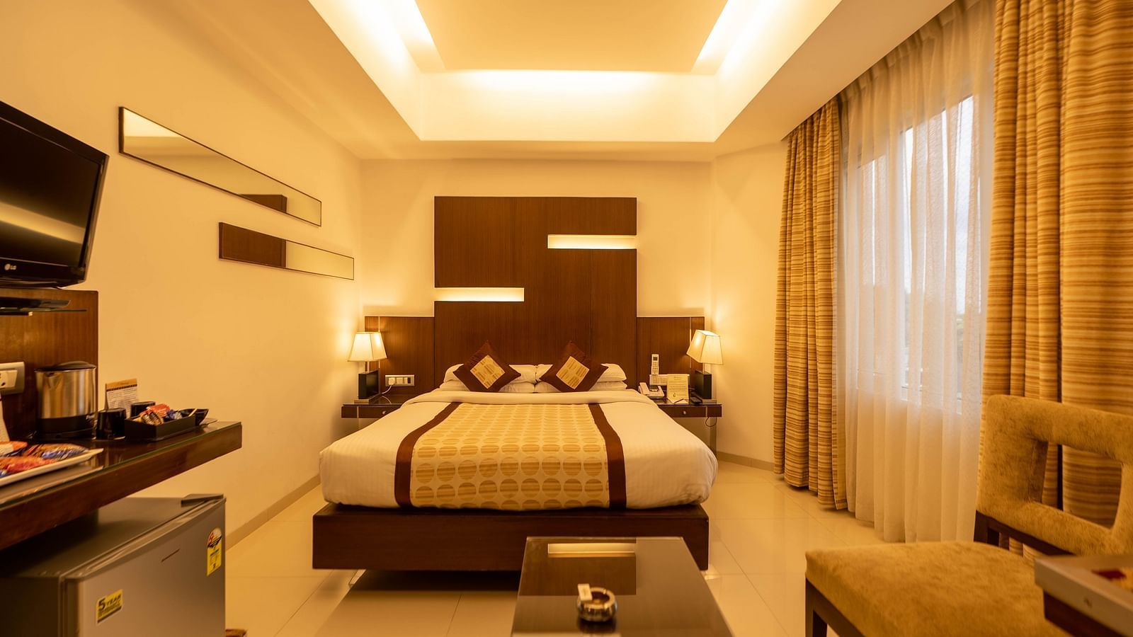 Modern and cosy hotel room with a spacious bed, seating area, sleek furnishings, and soothing lighting for a relaxing stay - The President Hotel Jayanagar, Bangalore