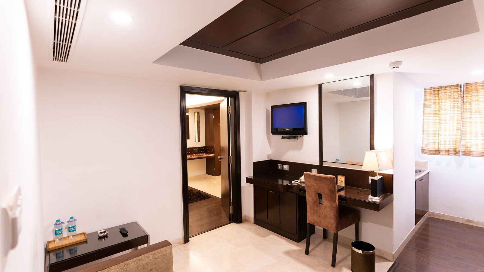 Spacious hotel suite with a plush seating area, modern amenities, sleek decor, and a welcoming atmosphere for a comfortable stay- The President Hotel Jayanagar, Bangalore