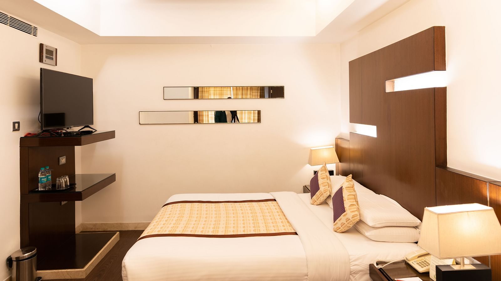 A warm and inviting hotel room with soft lighting and a comfortable bed at The President Hotel, Jayanagar