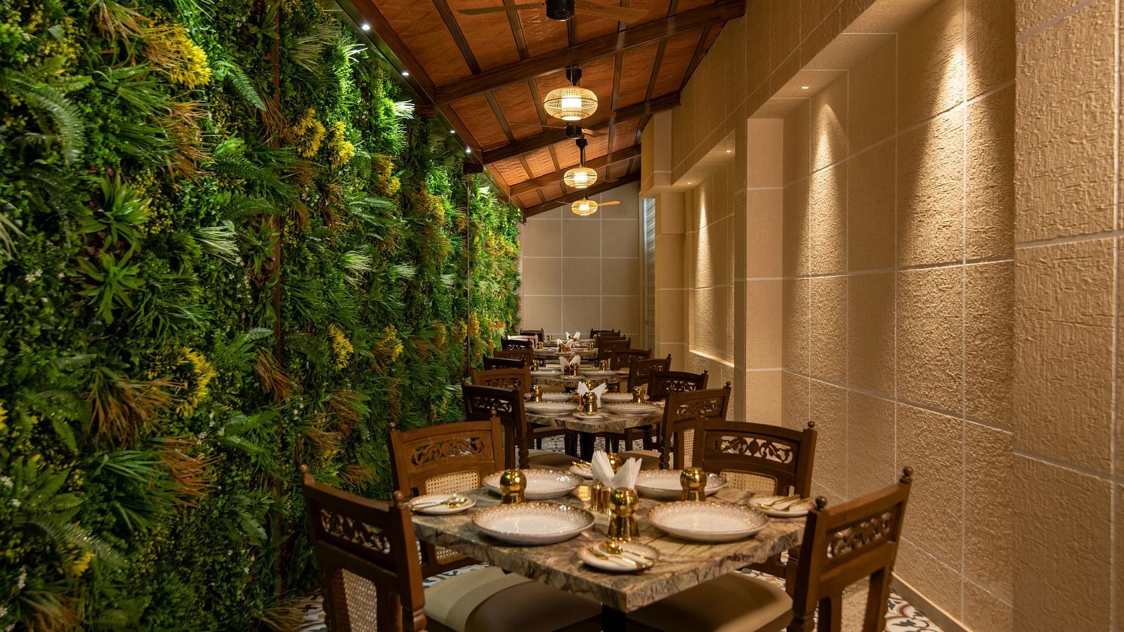 President Kumara Park - A dining area next to a wall decorated with leaves ge64fp