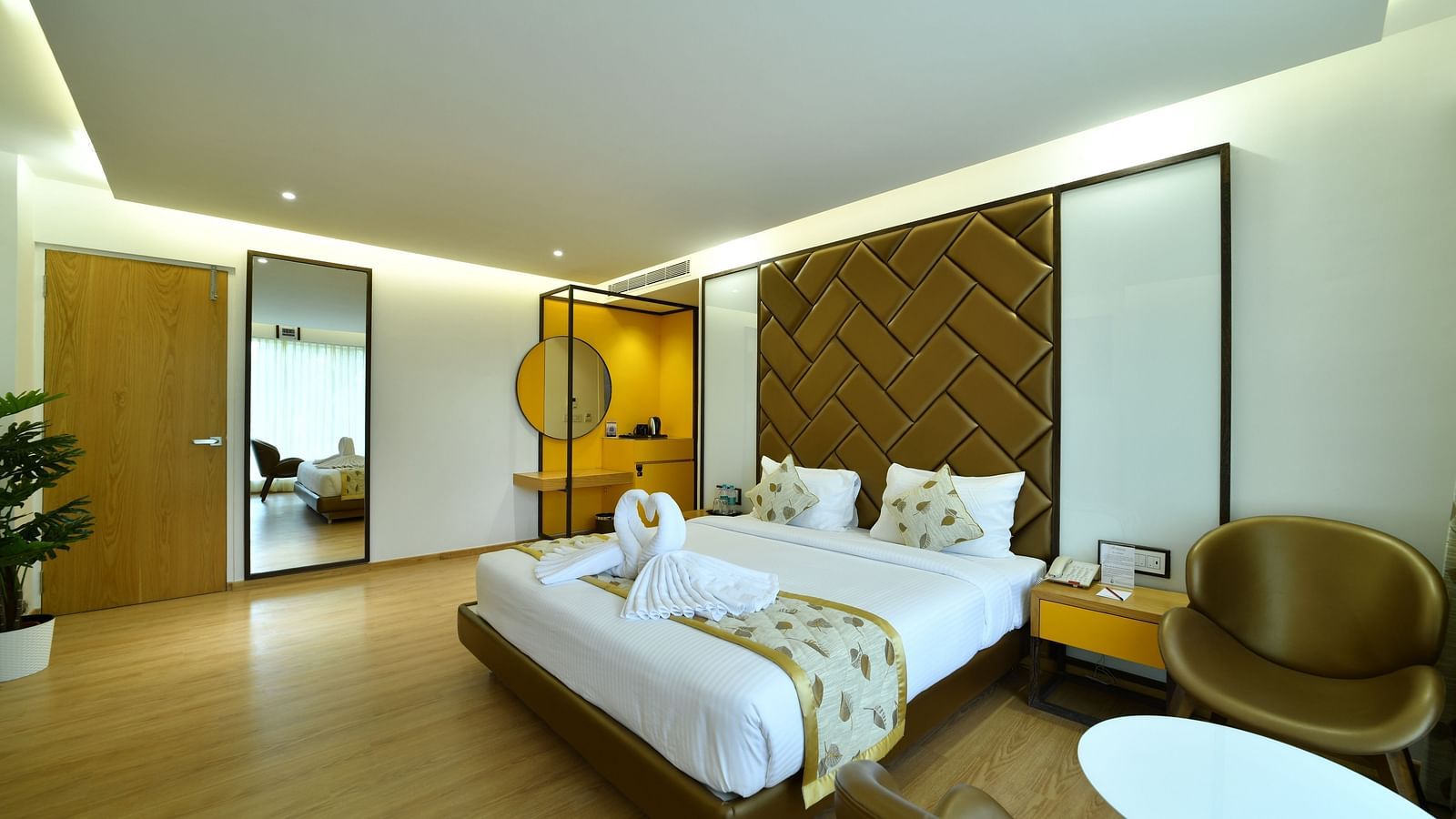 An image of a bedroom with a tea and coffee maker along with two chairs and a round table - The President Hotel, Kumara Park, Bangalore