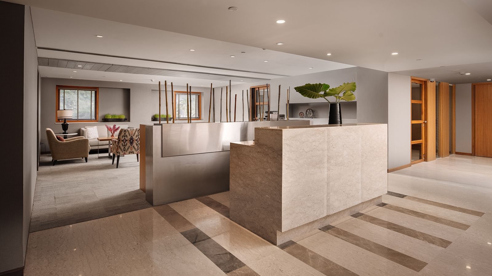 The reception area with contemporary design with the lobby area in the background, welcoming guests at The Raintree, St. Mary's Road.